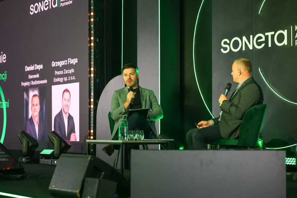 Grzegorz Flaga z Enology i Daniel Depa z Sonety na scenie, na ekranie plansza panelu Projekty i Budżetowanie