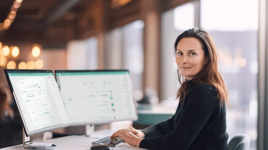 Pracowniczka serwisu przy dwóch monitorach – enova365 Serwis